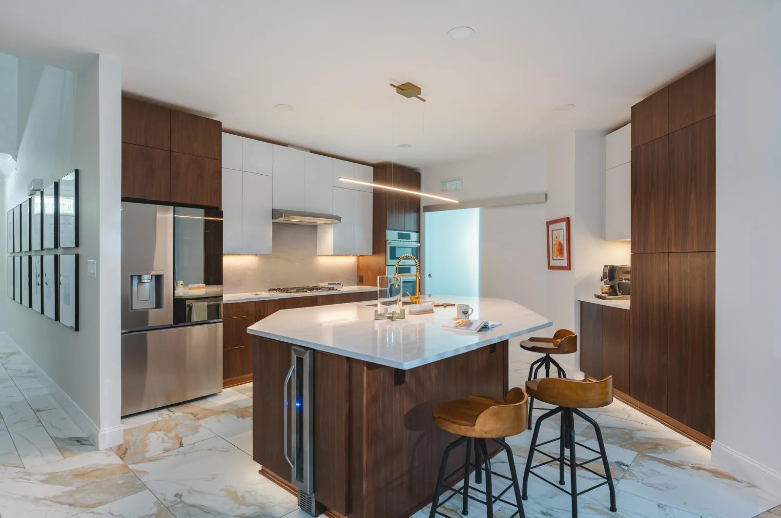 Stunning modern kitchen remodeling in Ellicott City MD, featuring sleek flat-panel two-tone cabinets, a geometric island, and gold accents by Anka Design Studio.