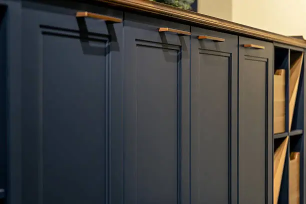 Flat-panel navy kitchen cabinets with gold hardware