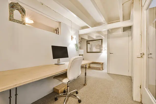 Bright finished basement converted into a modern home office with built-in storage