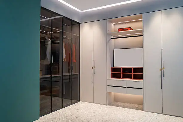 His and hers custom closet with navy and white cabinetry meeting at a marble topped center island